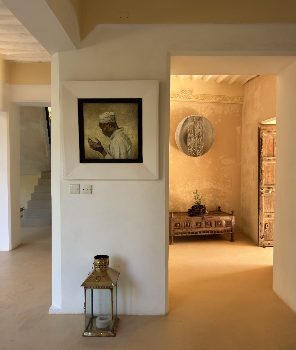 Framed portrait of a man in prayer in a white Lamu hallway